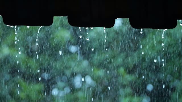 Rain Water Dropping From Roof In Day Time. Raining In Motion. Slow Motion.